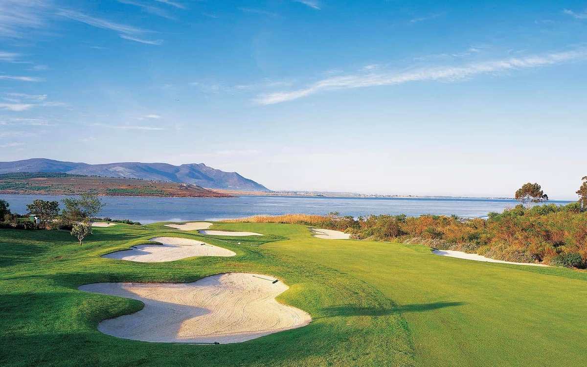 Green et bunkers face à une lagune et aux montagnes en Afrique du Sud