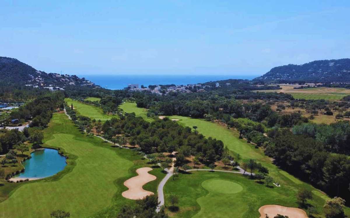 Vue aérienne d’un parcours de golf entre pins et Méditerranée à Majorque