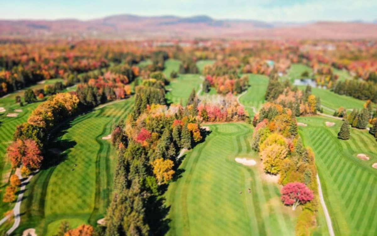 Vue aérienne d’un parcours de golf entouré de forêts aux couleurs d’automne au Canada