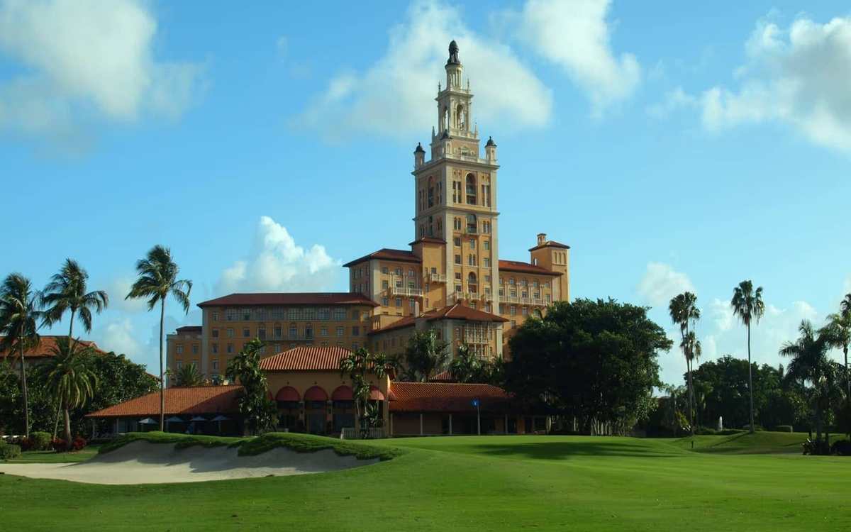 Hôtel historique et palmiers au bord d’un parcours de golf en Floride
