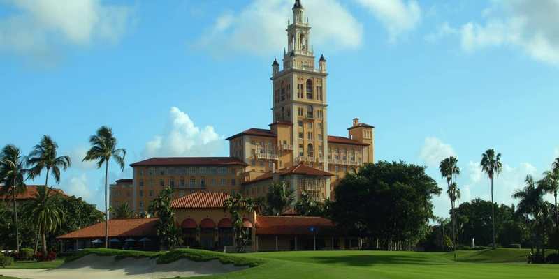 Hôtel historique et palmiers au bord d’un parcours de golf en Floride