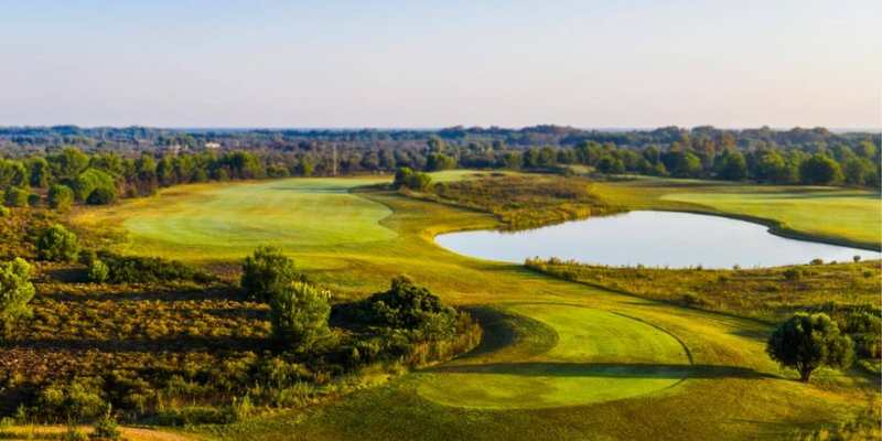 Parcours de golf et lac dans la campagne italienne
