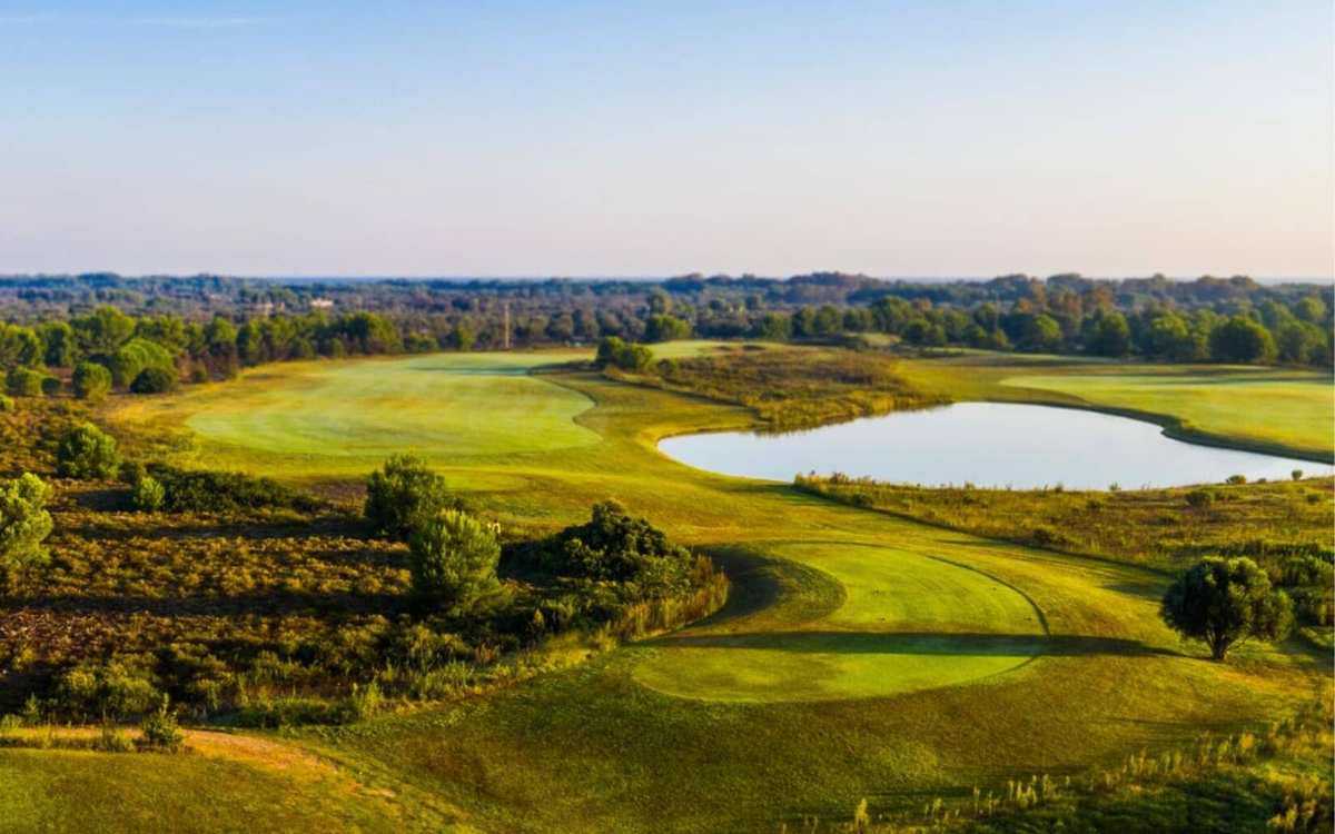 Parcours de golf et lac dans la campagne italienne