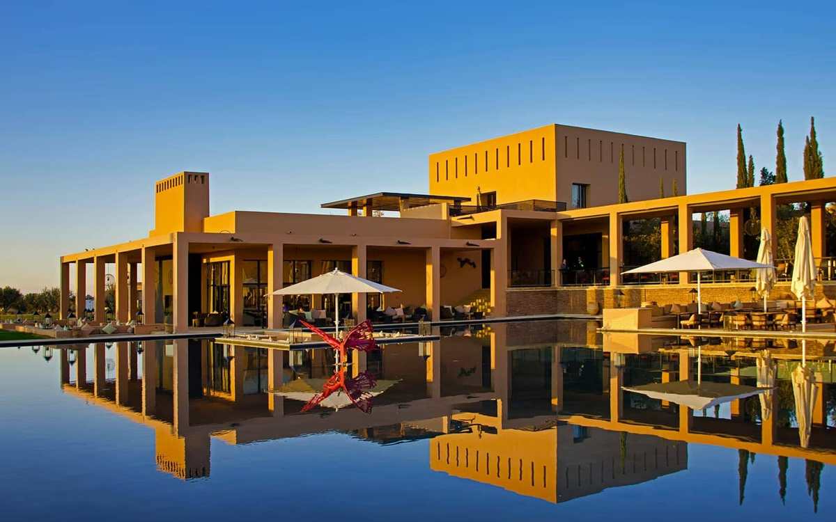 Hôtel aux lignes contemporaines se reflétant dans un bassin au Maroc