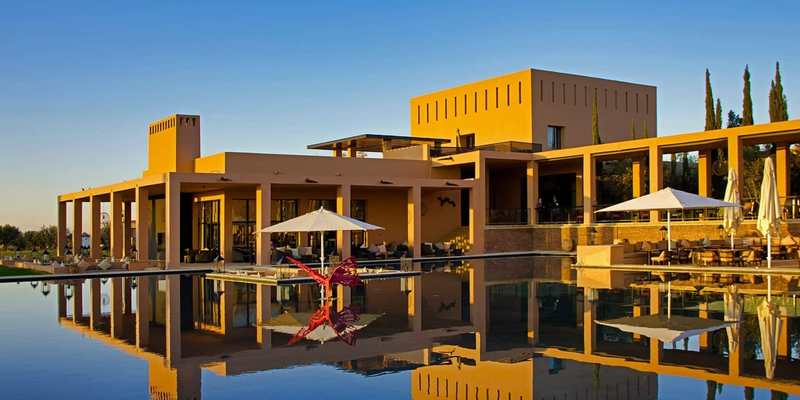Hôtel aux lignes contemporaines se reflétant dans un bassin au Maroc