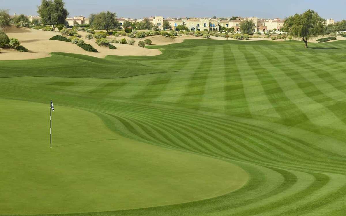 Fairway tondu en bandes face aux dunes, à Dubaï
